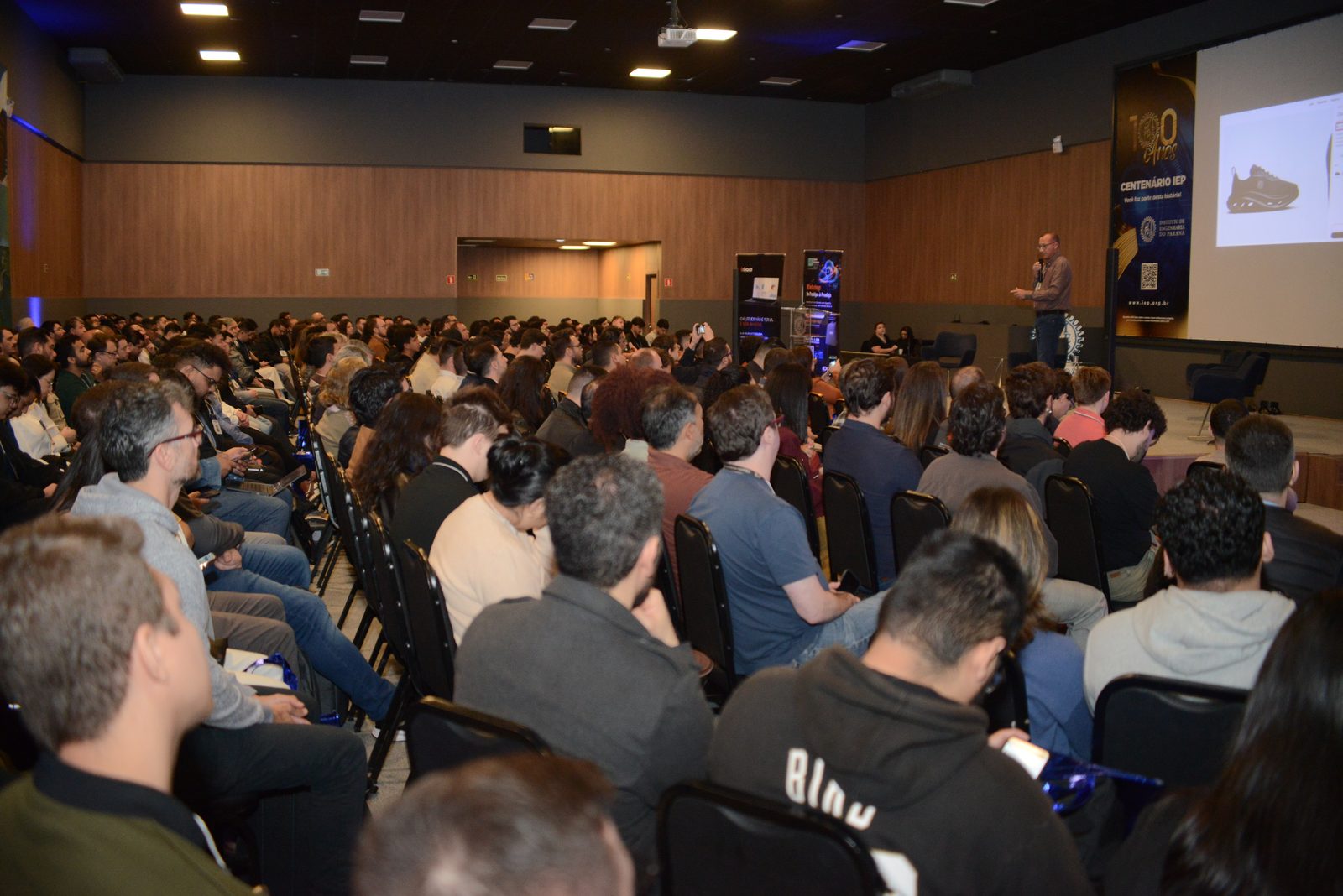 Plateia lota o auditório do Instituto de Engenharia do Paraná na palestra de Alex Assis no DSSBR 2026